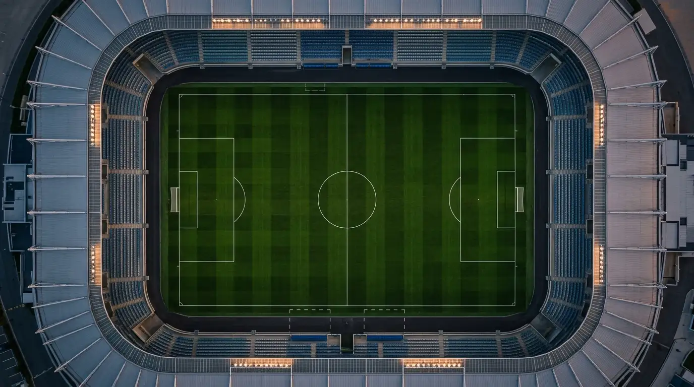 Vue aérienne d'un terrain de football avec les lignes du terrain bien visibles, éclairage de stade en soirée